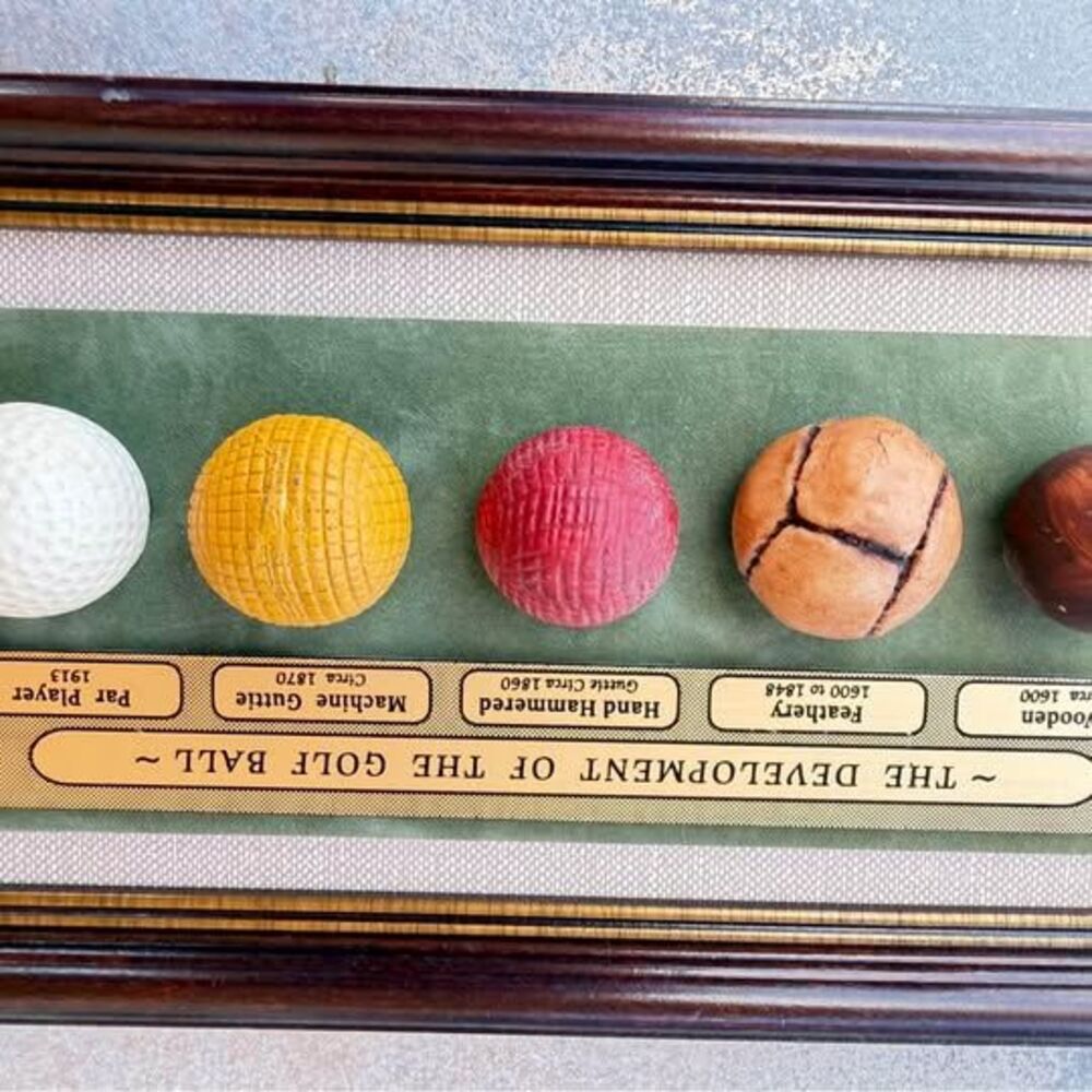 Vintage framed display illustrating
"The Development of the Golf Ball' through f